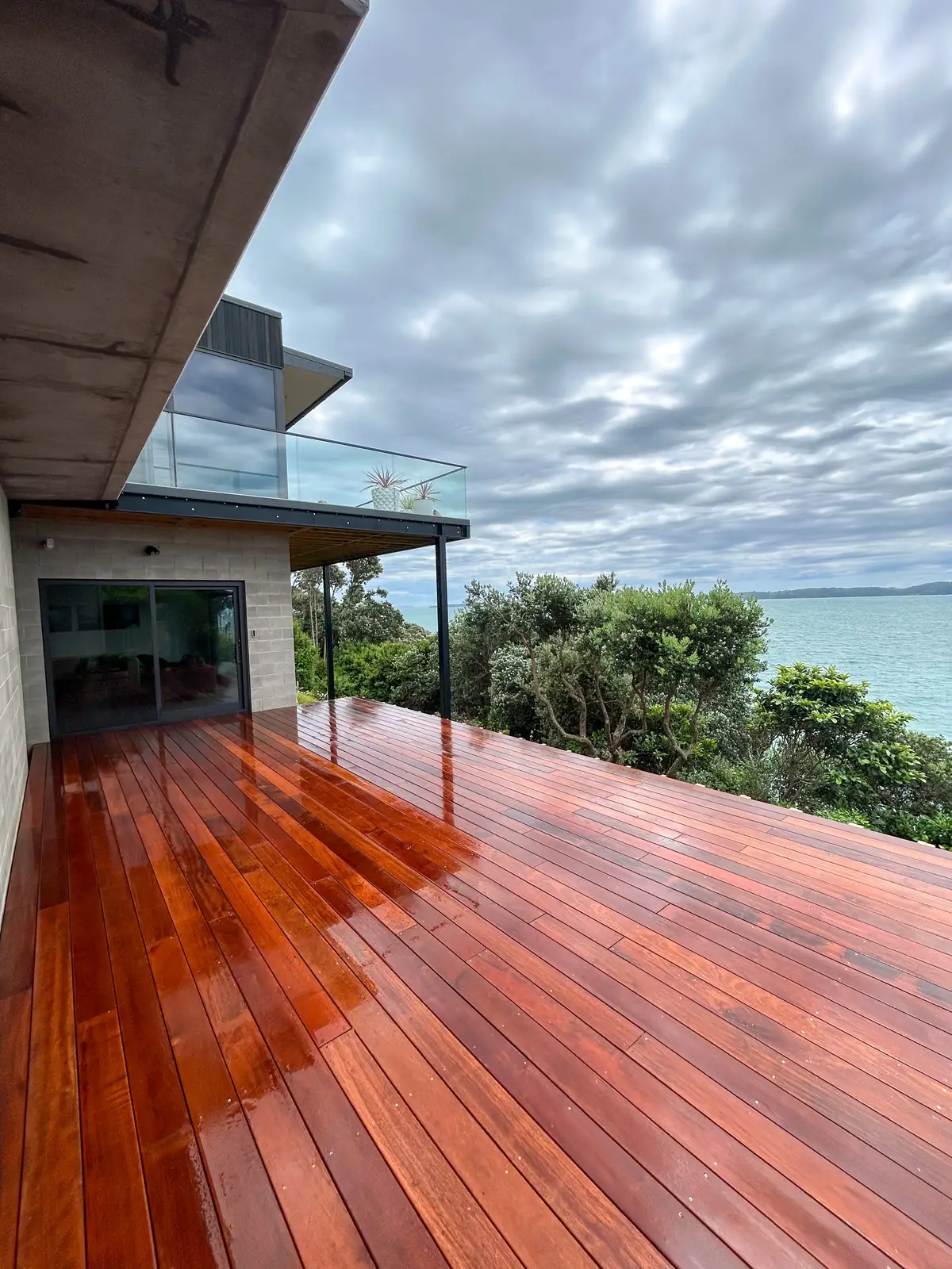 Timber deck extending out over a slope with a sea view