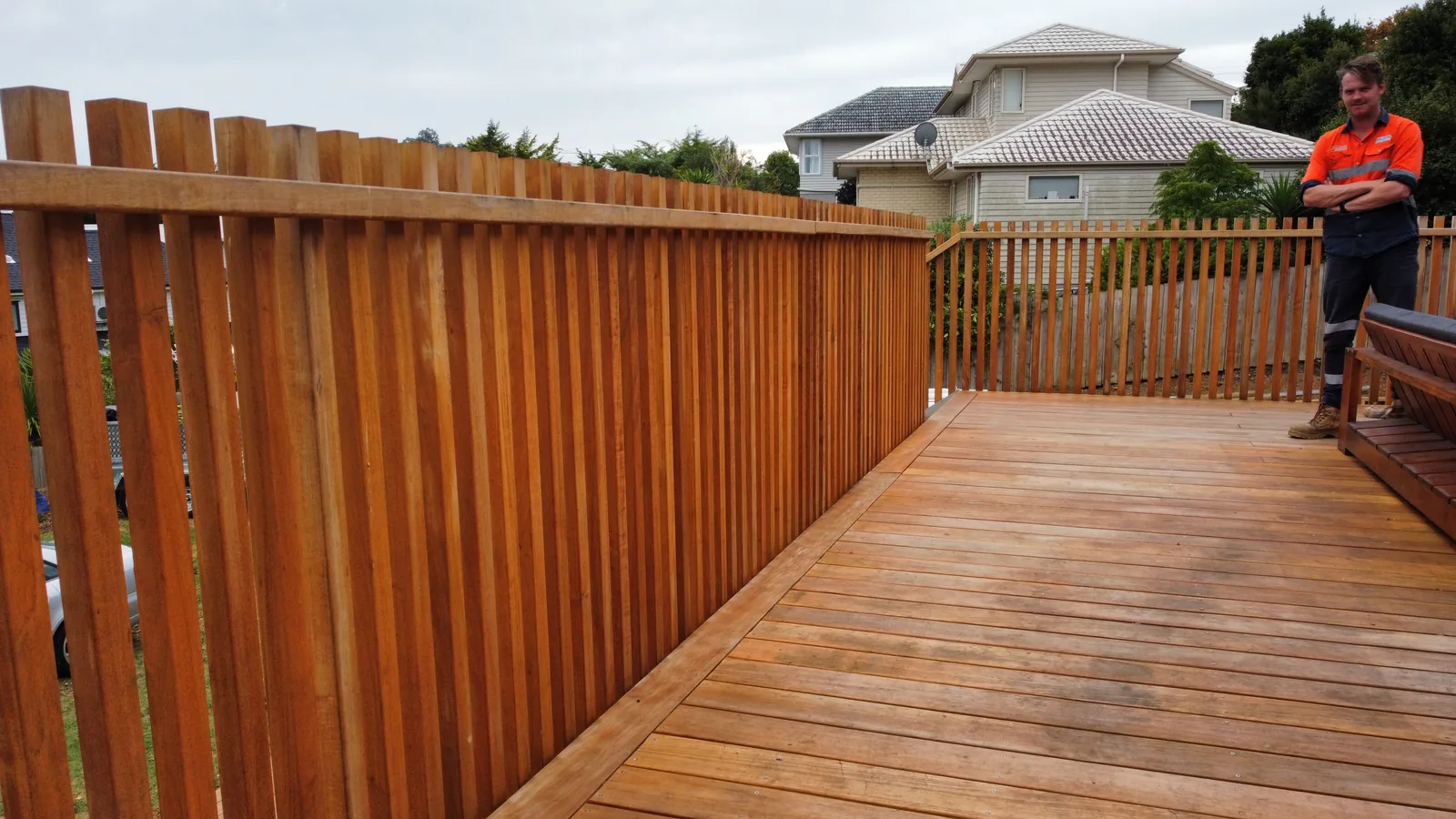 Person in a hi-vis vest beside a timber deck with a timber screen