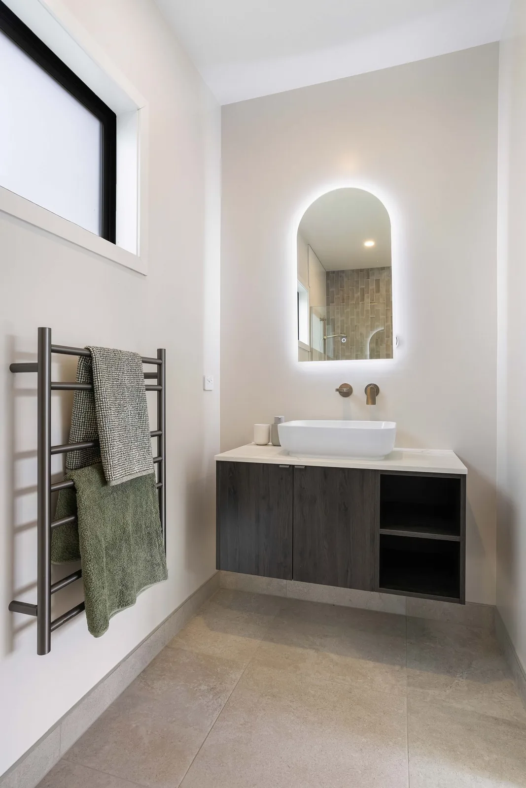 Bathroom vanity with a mirror and tiled wall