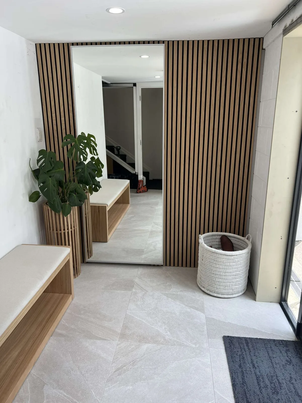 Entry with timber slat panels and a bench