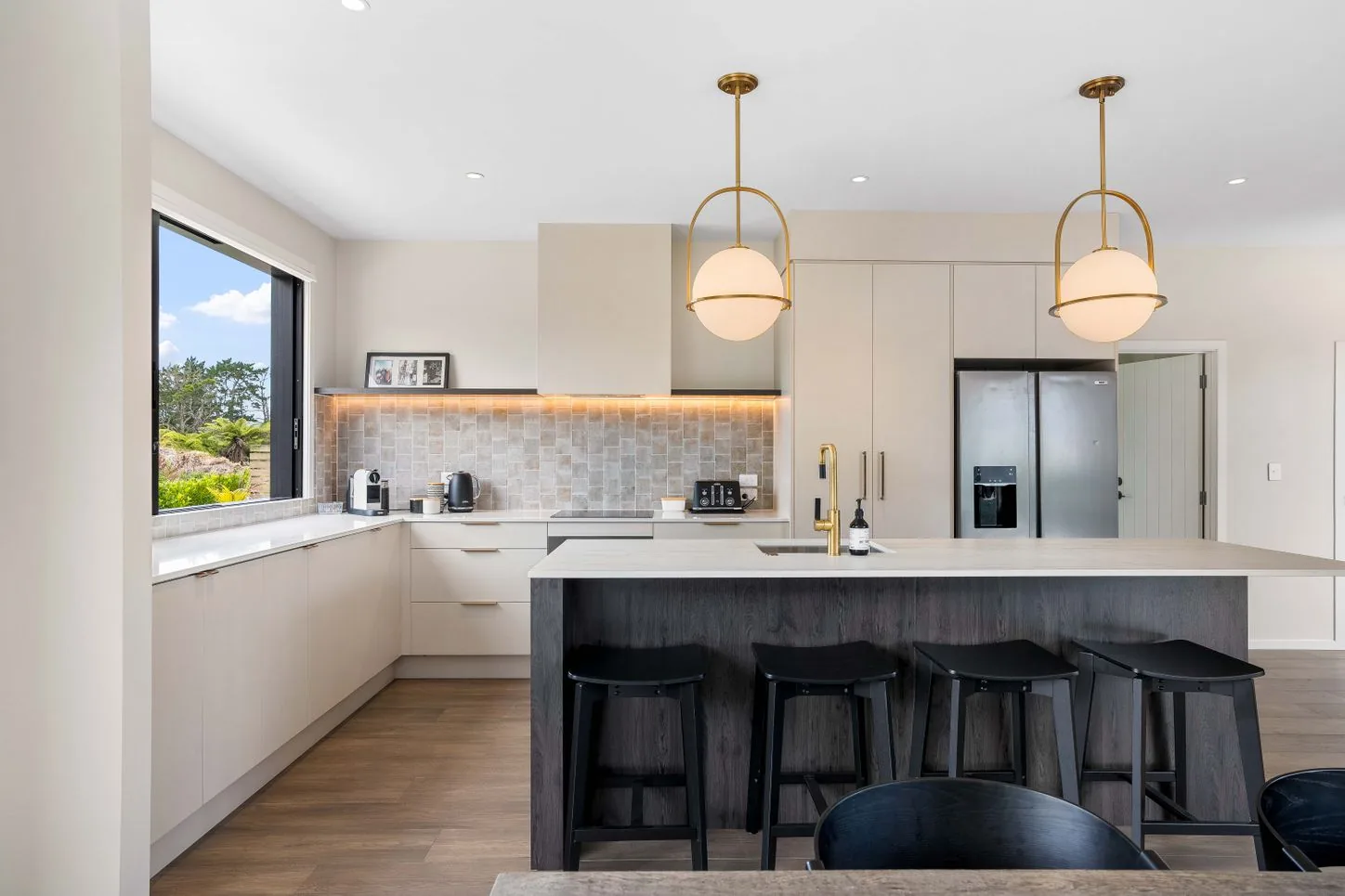 Kitchen island with brass pendant lights over the benchtop