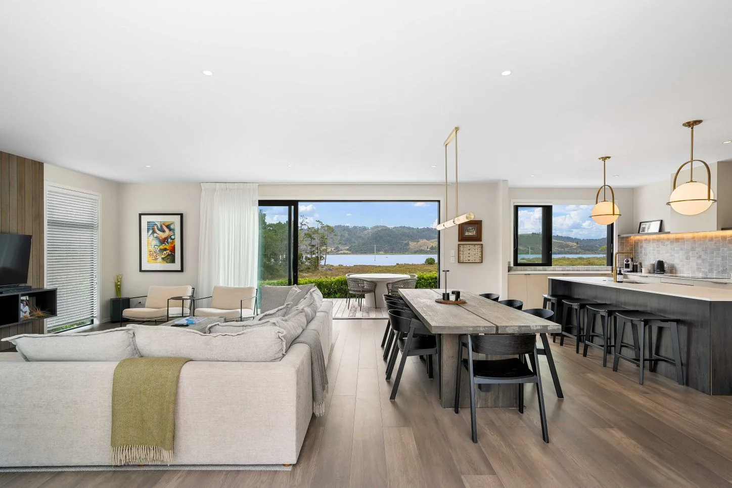 Open-plan living, dining and kitchen with a water view