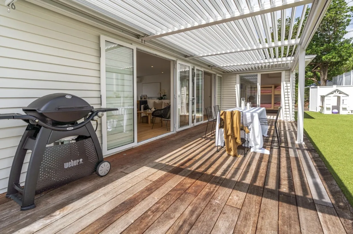 Timber deck under a louvre roof with a barbecue