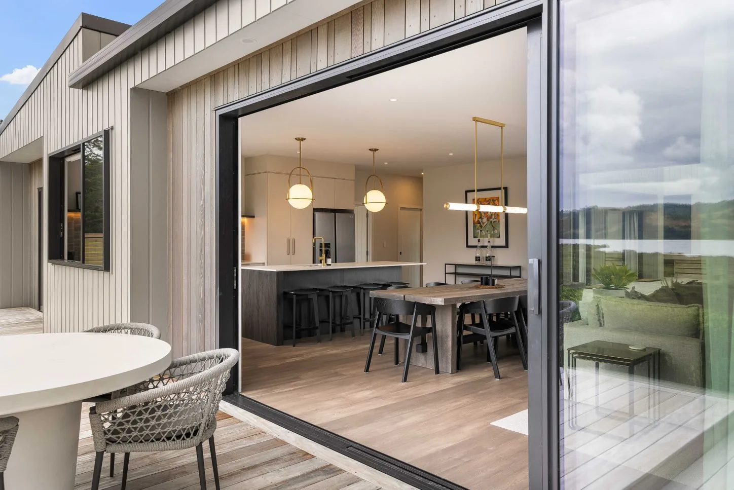 Sliding door from the kitchen out to a deck with a table