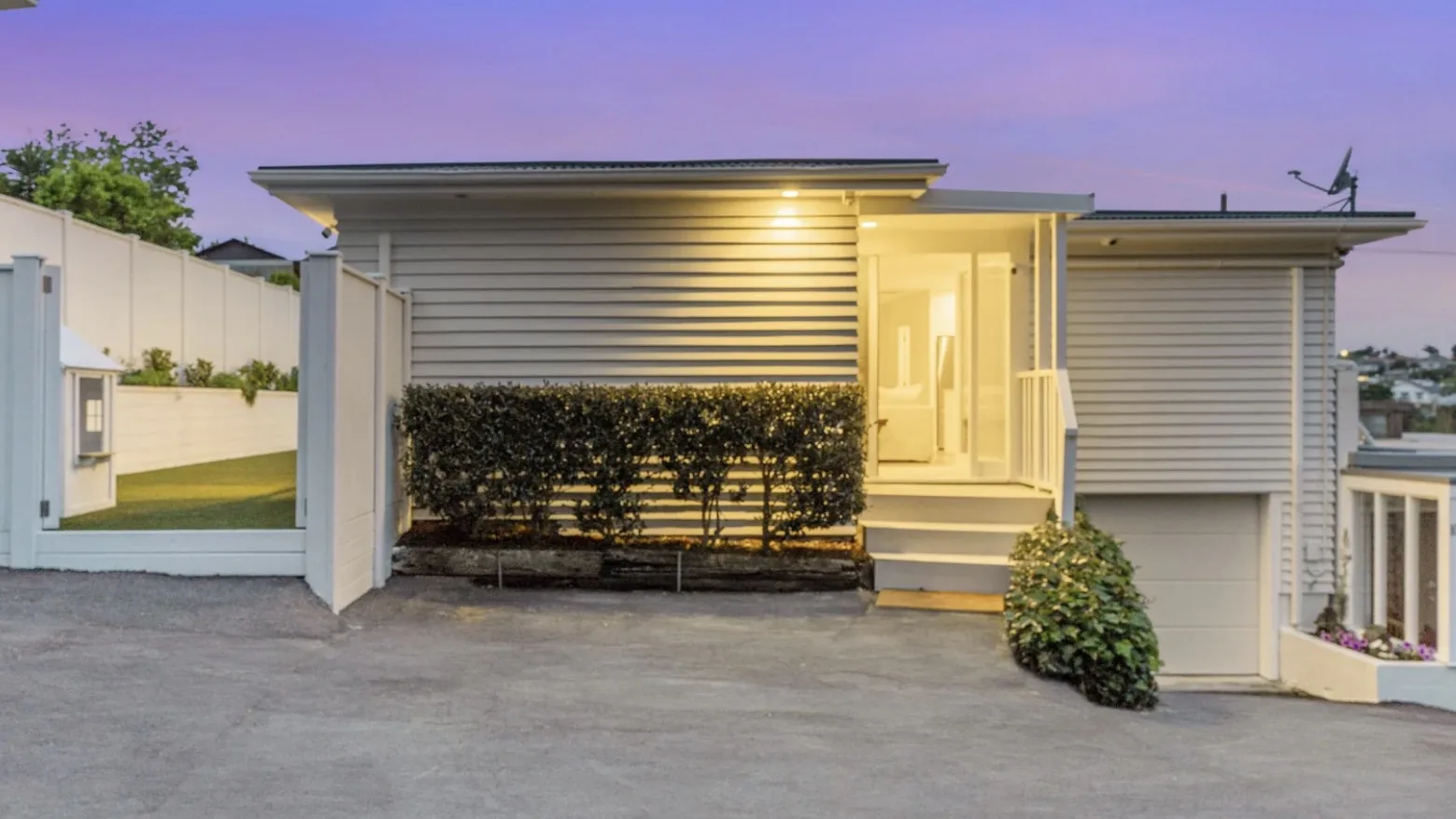White weatherboard house entrance at dusk